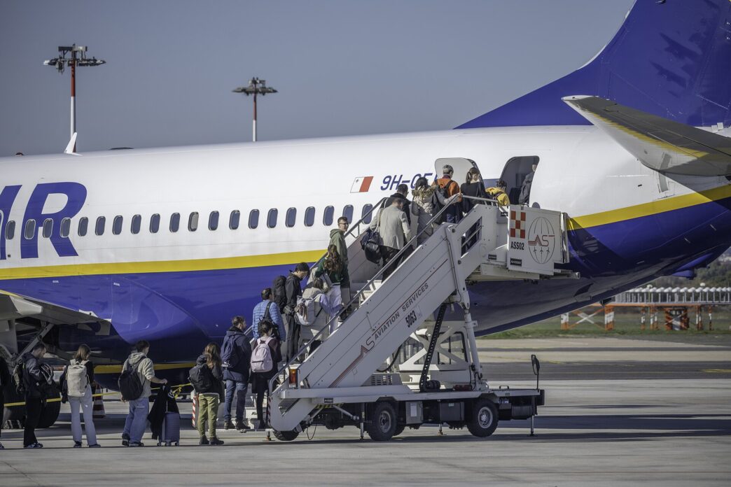 Pasażerowie wchodzą po schodkach do samolotu Ryanair