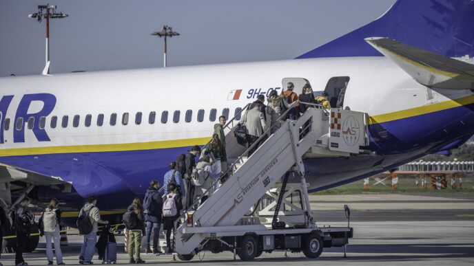 Pasażerowie wchodzą po schodkach do samolotu Ryanair