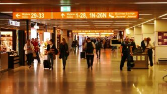 Przejście w terminalu lotniska z pasażerami i sklepami