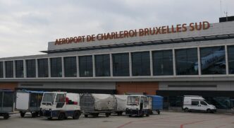 Terminal lotniska Charleroi od strony płyty postojowej, przed budynkiem pojazdy obsługi naziemnej
